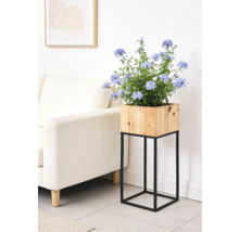 Support de plante moderne avec jardinière carrée en bois sur un support en métal noir dans un salon lumineux.