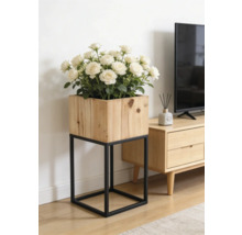 Jardinière carrée en bois sur un support en métal noir avec des roses blanches dans un salon lumineux à côté d'un meuble TV.