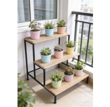 Étagère à plantes à trois niveaux avec cadre en métal noir et tablettes en bois sur un balcon lumineux avec diverses plantes en pot.