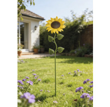 Gartenstecker Sonnenblume aus Metall auf einer Rasenfläche in einem hellen Garten mit Blumen.