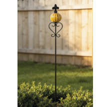 Tuteur de jardin décoratif en métal avec une boule en céramique jaune et des ornements en forme de cœur devant une clôture en bois.