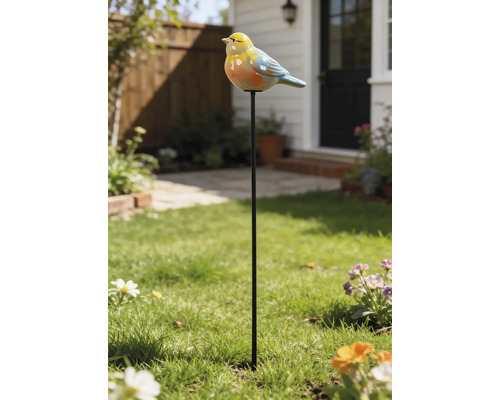 Piquet de jardin avec un oiseau coloré en céramique sur une tige métallique, placé dans une pelouse verte devant une maison.
