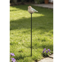 Pic de jardin en métal avec une figurine d'oiseau en céramique dans un jardin lumineux avec pelouse et fleurs.