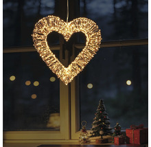 Beleuchtetes Deko-Herz aus Metalldraht mit zahlreichen warmweißen LED-Lämpchen, hängend vor einem Fenster mit Weihnachtsdekoration.