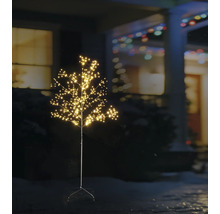 Beleuchteter LED-Dekobaum mit vielen kleinen Lichtpunkten für den Außenbereich in einem nächtlichen Garten vor einem Haus.