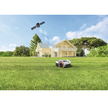 Mähroboter auf einem großen Rasen vor einem zweistöckigen Haus, satellitengestützte Navigation durch Signale aus dem Weltraum.