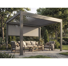 Pergola autoportante en aluminium anthracite avec toit à lames et store latéral dans un jardin avec salon de jardin.