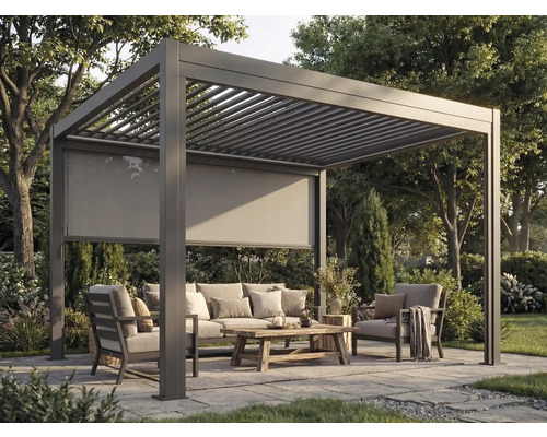 Pergola autoportante en aluminium anthracite avec toit à lames et store latéral dans un jardin avec salon de jardin.