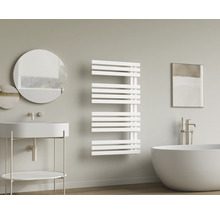 Radiateur de salle de bains blanc moderne dans une salle de bains lumineuse avec baignoire en îlot, lavabo et miroir rond.