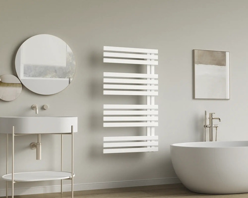 Radiateur de salle de bains blanc moderne dans une salle de bains lumineuse avec baignoire en îlot, lavabo et miroir rond.