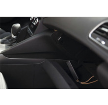 Appareil électronique compact dans une boîte à gants ouverte à l'intérieur d'une voiture, à côté du levier de vitesses.