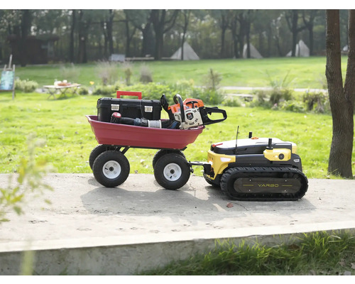 Robot de jardin polyvalent Yarbo tractant une remorque rouge contenant une boîte à outils et une tronçonneuse.