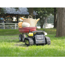 Un robot de jardin Yarbo à chenilles tractant une remorque de jardin rouge remplie de citrouilles et d'un panier en osier sur une pelouse.