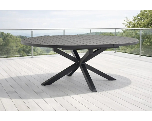Table de jardin ronde en métal avec plateau à lattes et piètement en étoile sur une terrasse.