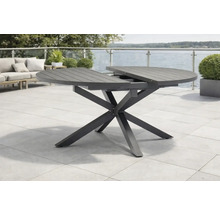 Table de jardin ronde extensible avec piètement en X et plateau à lattes sur une terrasse.