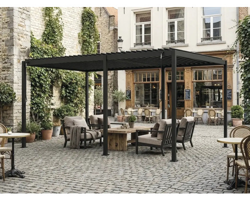 Pergola autoportante en aluminium avec toit à lames, salon de jardin avec table en bois sur une cour pavée.