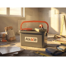 Kit de nettoyage pour carrelage AkKit avec seau, rouleaux et taloche éponge sur un chantier avec carrelage et outils.