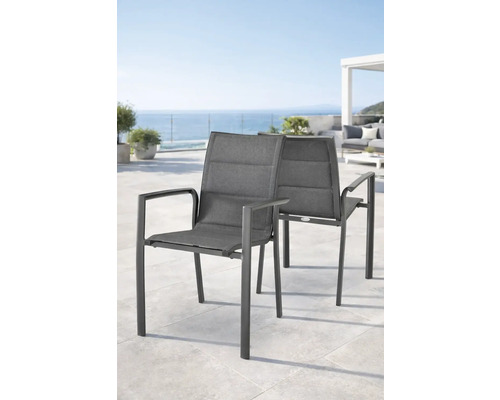 Deux chaises de jardin modernes avec accoudoirs sur une terrasse lumineuse avec vue sur la mer.