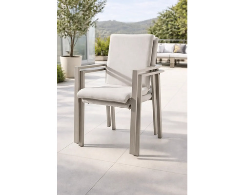 Chaises de jardin empilables avec structure en métal et coussins sur une terrasse.