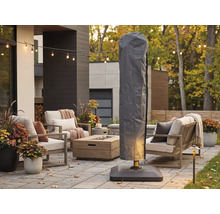 Graue Schutzhülle für Ampelschirm auf einer modern eingerichteten Terrasse mit Loungemöbeln, Feuertisch und Lichterkette.