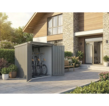 Moderner Metall-Fahrradschuppen in Grau auf einer Terrasse neben einem Wohnhaus. Zwei Fahrräder sind im Inneren platzsparend verstaut.