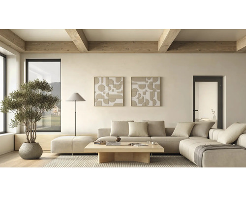 Helles, modern eingerichtetes Wohnzimmer mit beigem Ecksofa, Holztisch, zwei abstrakten Wandbildern, Stehlampe und Pflanze unter Holzdeckenbalken.