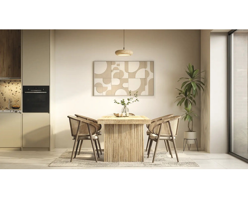 Hell gestalteter Essbereich mit einem Holztisch mit Lattenfuss, vier Rattanstühlen auf einem Teppich, Wandbild, Pflanze und moderner Küche.