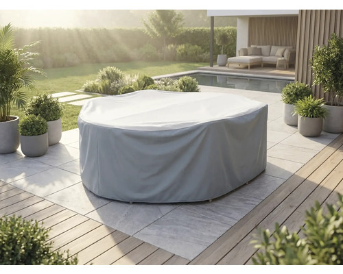 Graue Schutzhülle für eine runde Gartenmöbelgruppe auf einer hellen Steinterrasse in einem gepflegten Garten mit Pool und Pflanzen.