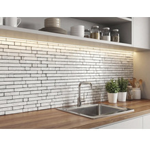 Küche mit einem Fliesenspiegel aus weißen Mosaikfliesen in Ziegeloptik mit Marmorstruktur, Holz-Arbeitsplatte, Edelstahlspüle und LED-Beleuchtung.