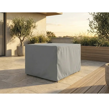 Housse de protection rectangulaire pour meubles de jardin sur une terrasse avec plantes en pots et sol en pierre à la lumière du jour.