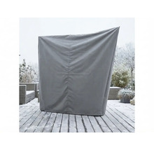 Housse de protection grise pour un fauteuil de plage sur une terrasse en bois enneigée dans le jardin.