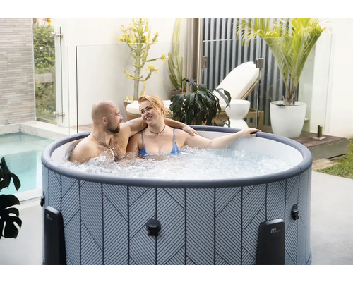 Jacuzzi gonflable avec motif géométrique sur une terrasse lumineuse avec des plantes et un couple.