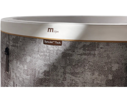 Gros plan d'un jacuzzi MSpa avec le MSpa Logo et le marquage SyncJet Tech sur une paroi extérieure grise et structurée.