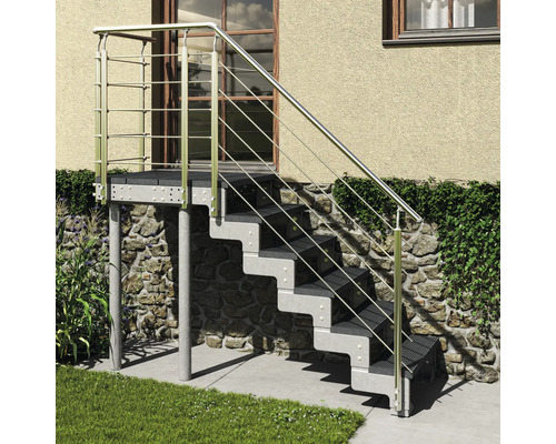 Escalier extérieur en métal avec six marches, un palier et un garde-corps devant un mur de maison.