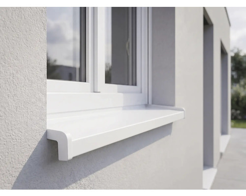 Appui de fenêtre extérieur blanc en plastique installé sous une fenêtre sur une façade en crépi clair.