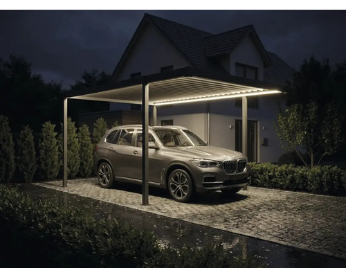 Carport moderne en aluminium avec éclairage LED intégré, toit à lames et SUV garé sur une allée pavée de nuit.