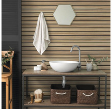 Salle de bain moderne avec panneaux muraux en lattes de bois, vasque à poser blanche sur une étagère en bois et miroir hexagonal.