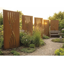 Plusieurs parois de protection visuelle en acier Corten couleur rouille avec découpes décoratives dans un jardin avec chemin de gravier.