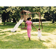 Tour de jeux en bois avec toboggan et balançoire dans un jardin lumineux avec une femme et un enfant.