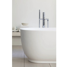 Baignoire îlot ovale avec robinetterie sur pied en chrome et douchette dans une salle de bains moderne et lumineuse.
