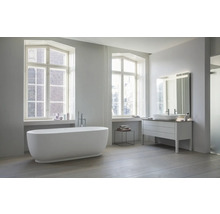 Salle de bains moderne et lumineuse avec baignoire en îlot robinetterie sur pied meuble sous vasque et grand miroir éclairé