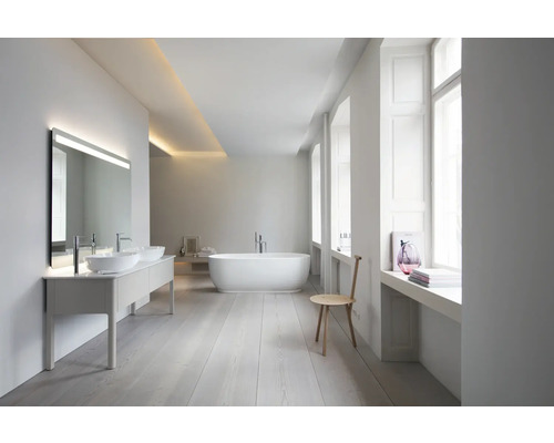 Salle de bains spacieuse et lumineuse avec double vasque, miroir LED, baignoire en îlot et parquet clair dans un style moderne et minimaliste.