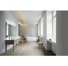 Salle de bain moderne et lumineuse avec double vasque, grand miroir, baignoire en îlot, sol en bois et grandes fenêtres.