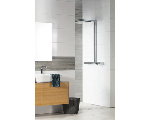 Modernes Badezimmer mit weißen und grauen Fliesen, Waschtischunterschrank in Holzoptik, weißem Aufsatzbecken und verchromter Regendusche.