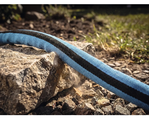 Ein Textilgartenschlauch wird über eine scharfe Gesteinskante gezogen um die Robustheit und Abriebfestigkeit zu demonstrieren.