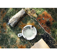 Spa gonflable dans le jardin vue de dessus avec deux personnes, tronc d'arbre et terrasse en bois.