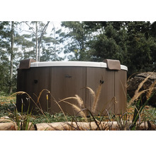 Spa MSpa rond avec habillage extérieur aspect bois et deux appuie-tête dans un jardin.
