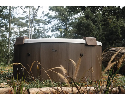 Spa MSpa rond avec habillage extérieur aspect bois et deux appuie-tête dans un jardin.