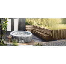 Spa gonflable Intex de forme ronde avec aspect bois sur une terrasse en bois à côté d'un banc d'angle en bois.