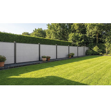 Moderner Sichtschutzzaun aus grauen Faserzementplatten mit dunklen Metallpfosten in einem gepflegten Garten mit Rasen und Hecke.